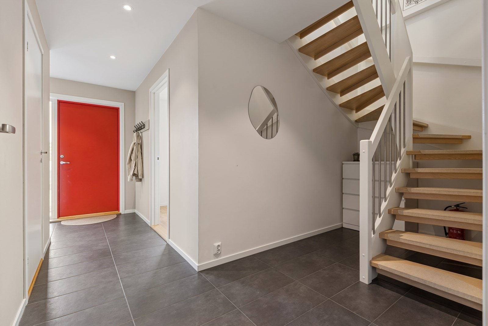 Man ønskes velkommen inn i en romslig gang som er praktisk innredet med flislagt gulv. Her har man god plass til å henge fra seg yttertøy og sko. Galleribilde