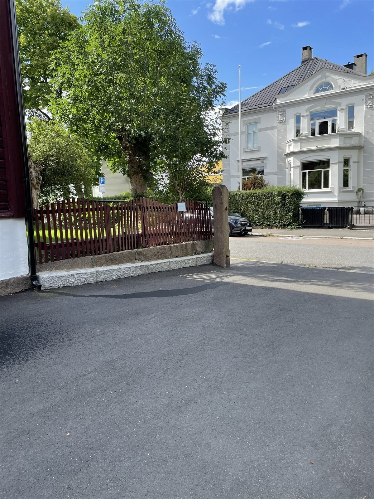 Gårdsplass med nyere asfalt og parkering - 1 p-plass til hver av de tre seksjonseierne, inngang til frodig, nydelig felles have. Galleribilde