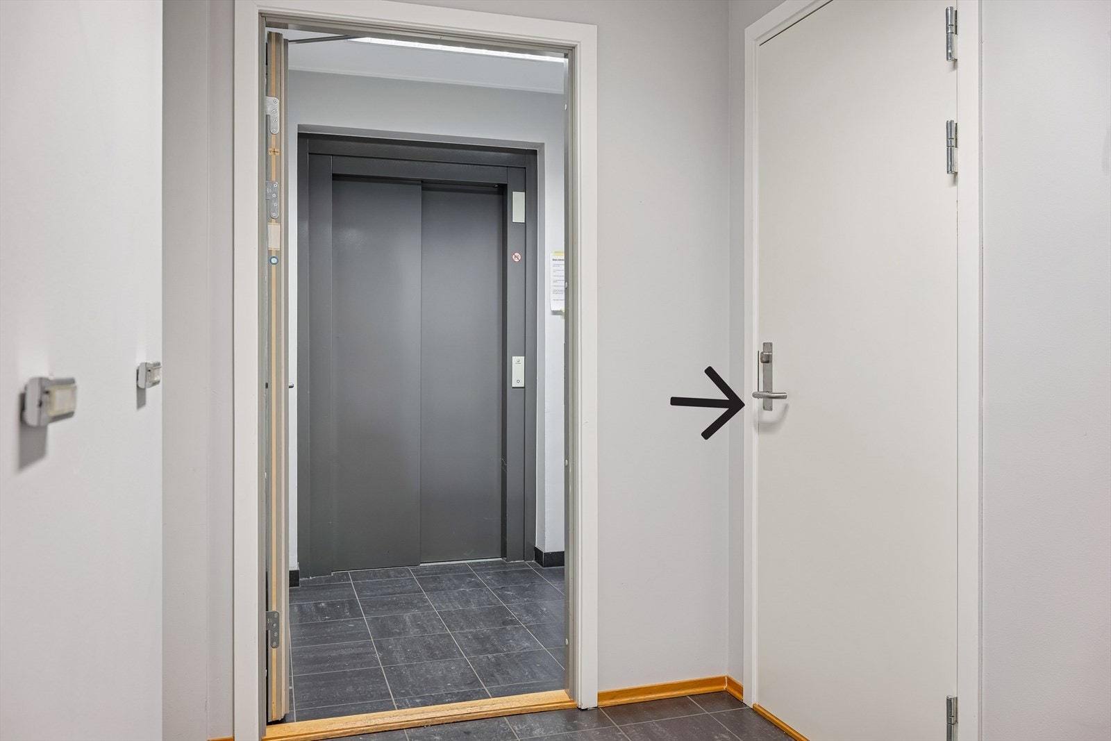 Noen få skritt fra heis og sportsbod til leiligheten. Pilen viser døren til bod. Galleribilde