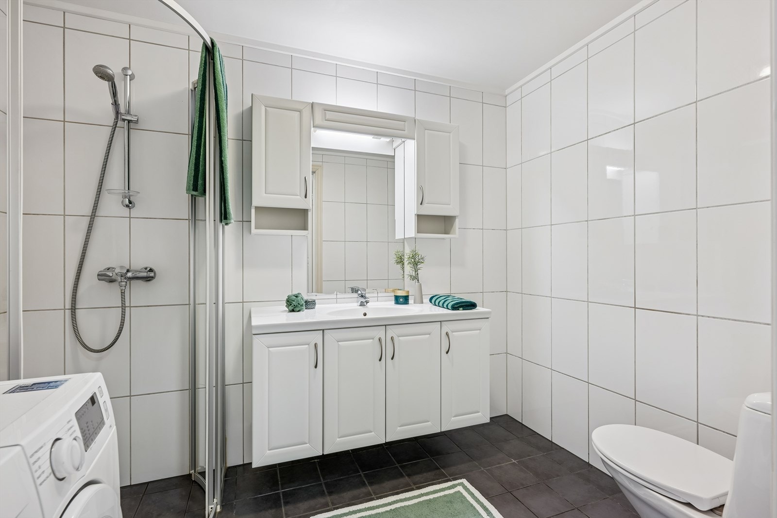 Baderommet er innredet med baderomsinnredning m/nedfelt servant, dusjhjørne med glassdører og toalett. Galleribilde