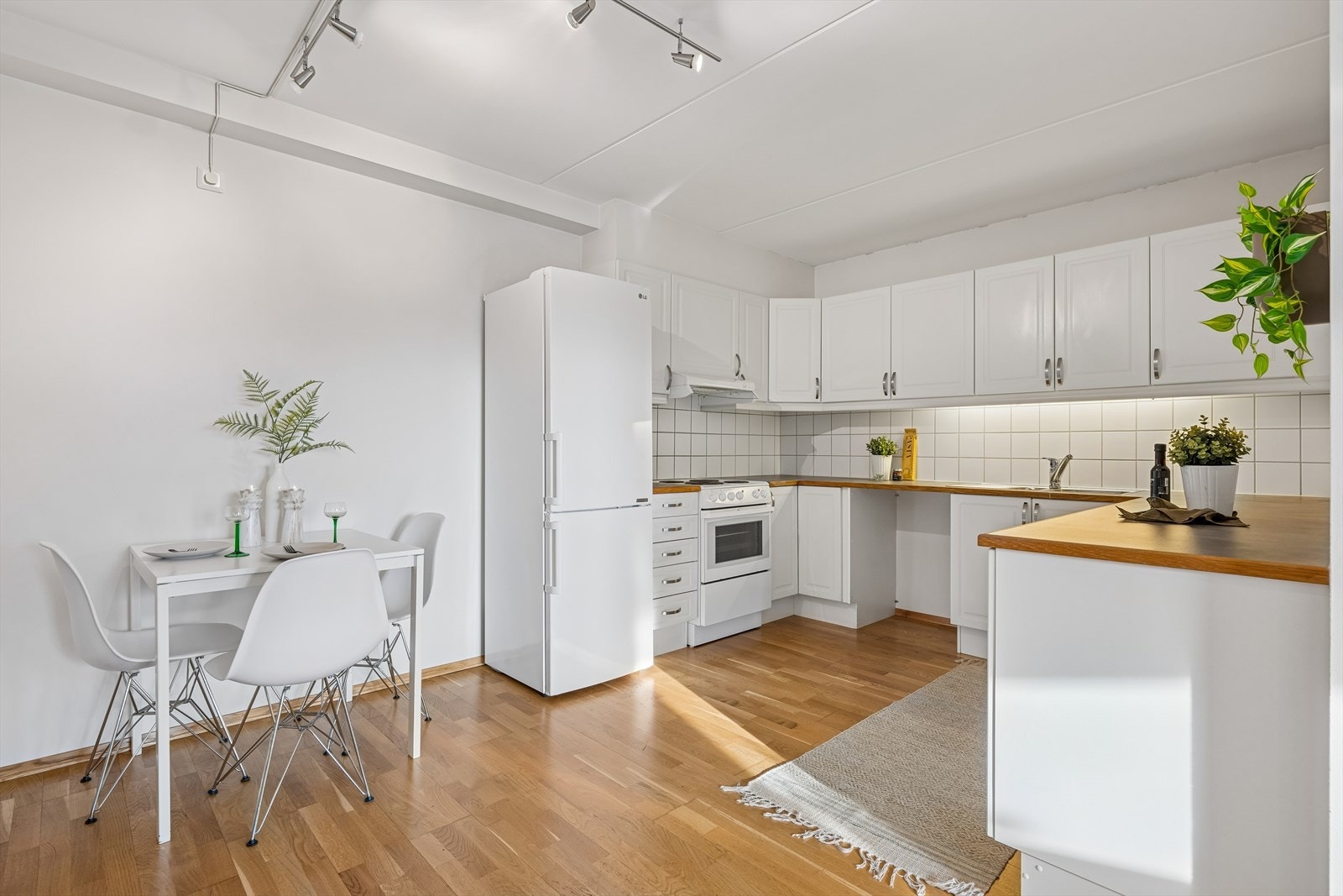 Et praktisk kjøkken fra 2008 med hvit, profilert innredning og rikelig med både benke- og skapplass. Galleribilde