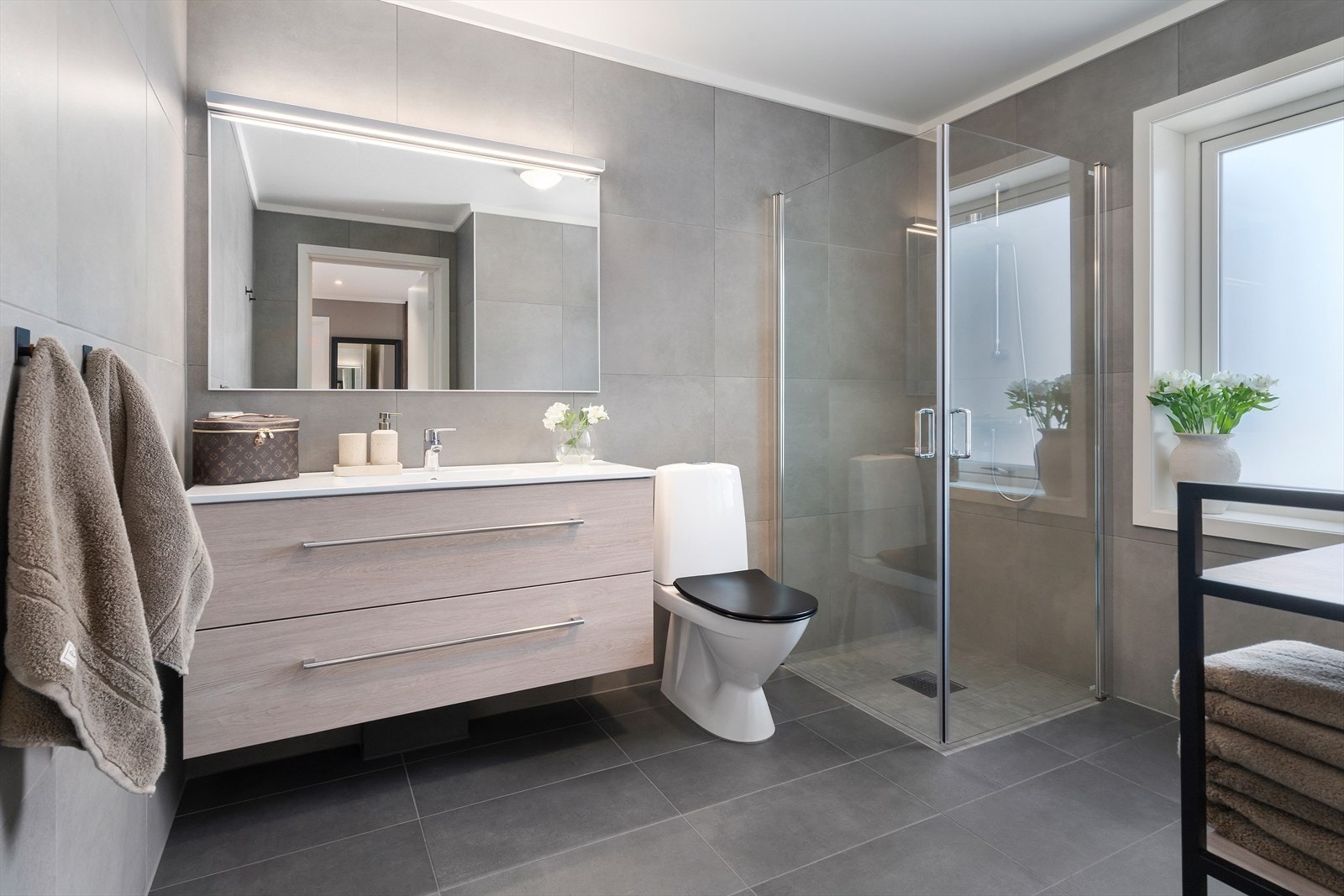 Boligen har et moderne innredet bad i 1.etasje med pene fliser og mosaikkfliser i dusjsone. Galleribilde