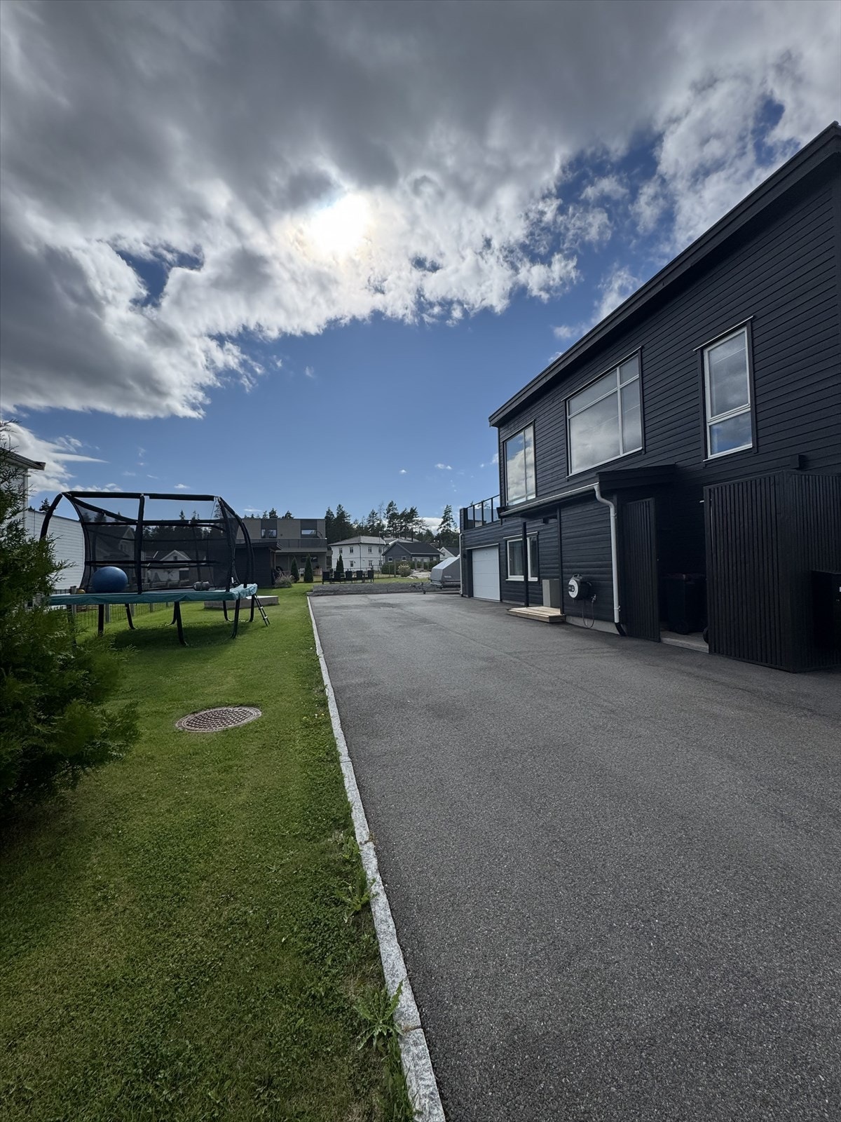 Selgers bilde. Sommerbilde viser asfaltert gårdsplass og kantstein. Galleribilde