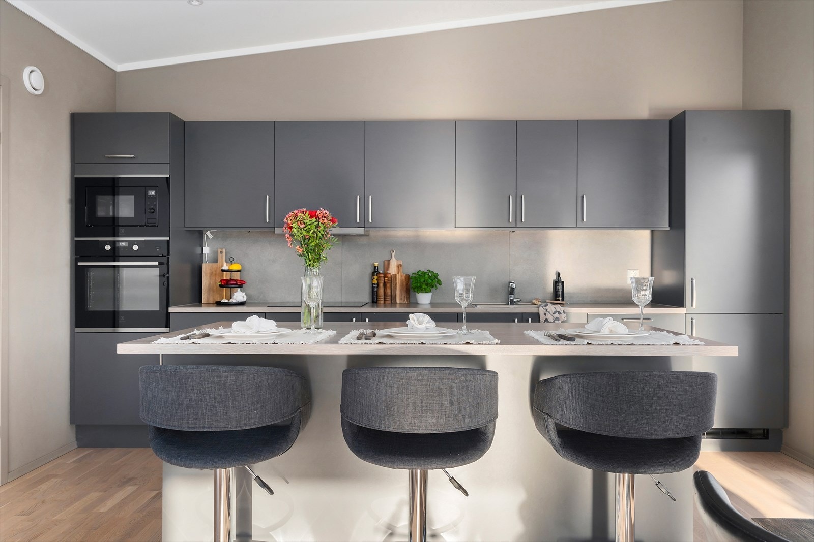 Den romslige innredningen fungerer både som en praktisk arbeidsflate og som en innbydende barløsning med sitteplass til flere - perfekt for uformelle måltider, sosial matlaging og gode samtaler mens man lager mat. Galleribilde