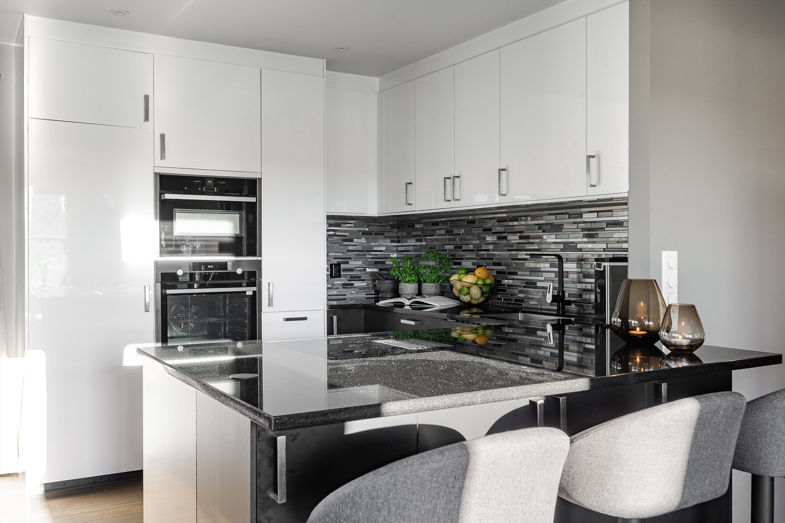 Kjøkkenet var nytt i 2024. Lyse og glatte fronter, solid steinplate og barløsning mot stuen. Galleribilde