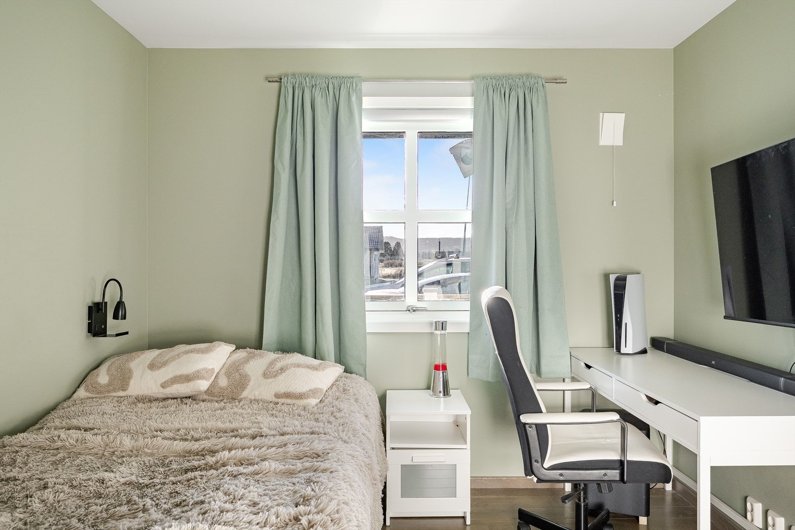 Plass til dobbeltseng og skrivebord gjør rommet funksjonelt for både hvile og arbeid. Galleribilde