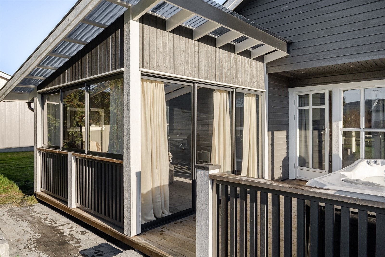 Innglasset veranda som har teppefliser og innlagt strøm, noe som gir komfort og funksjonalitet. Galleribilde