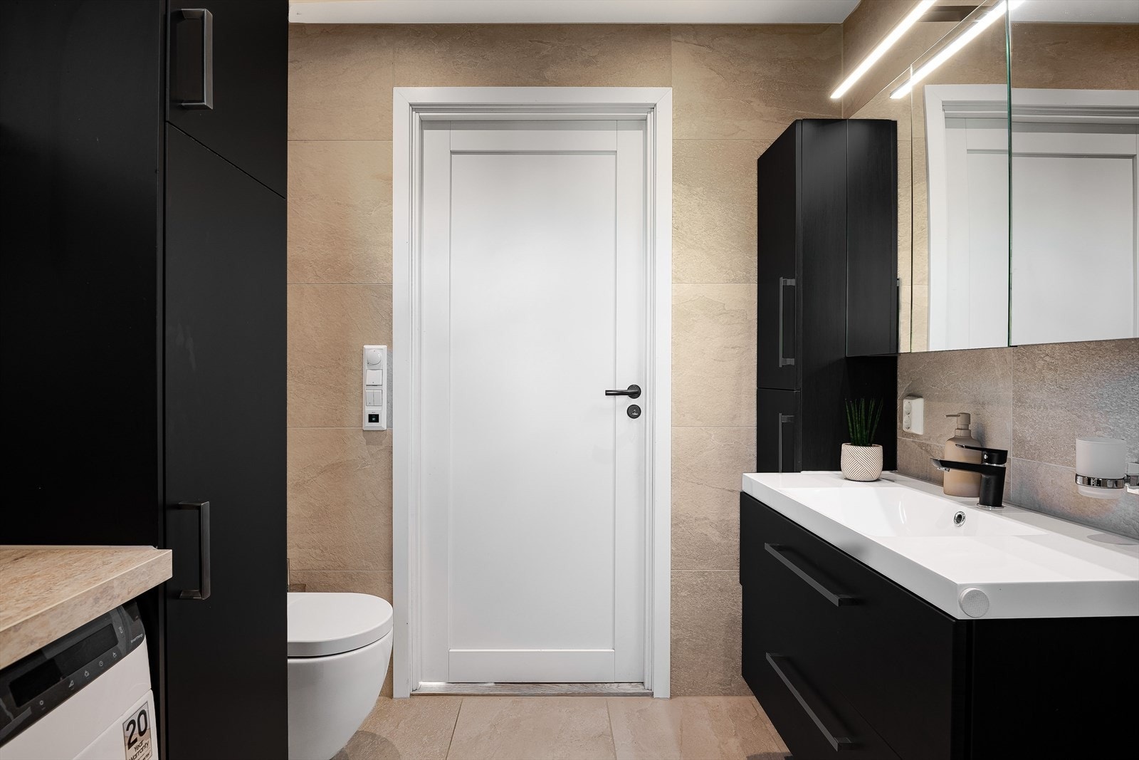 Vegghengt toalett med skjult sisterne og elektrisk styrt vifte. Galleribilde