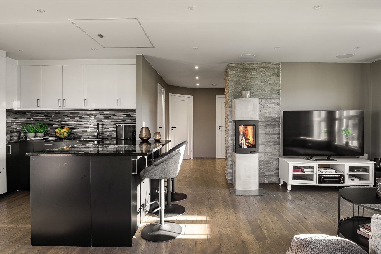 Sosial og åpen romløsning. Vedovn midt i rommet som gir effektiv og god varme på kalde dager, og ikke minst skaper en lun atmosfære. Galleribilde