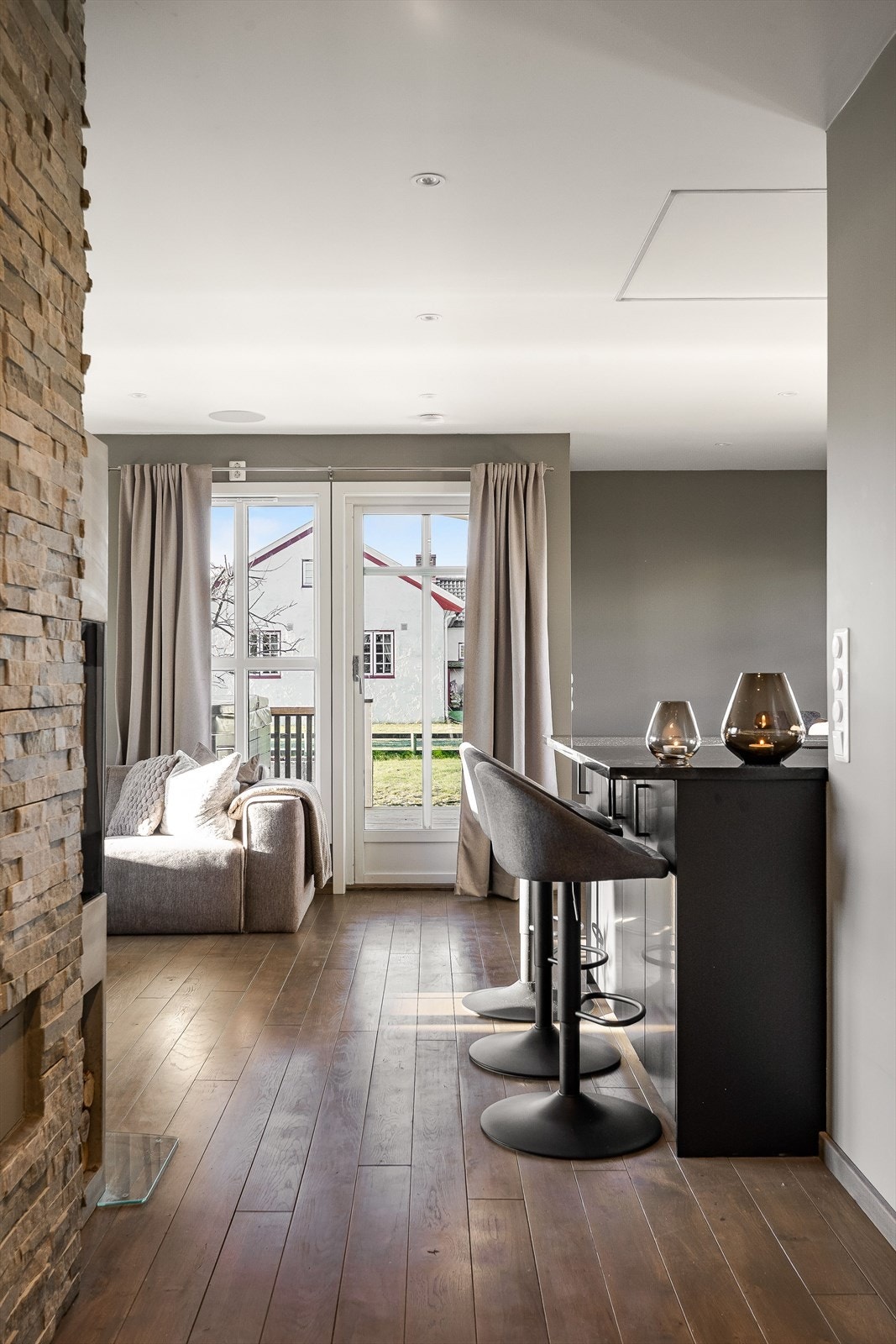 Vinduer fra byggeår og verandadør fra 2019 som gir et naturlig og fint lysinnslipp til oppholdsrommet. Galleribilde