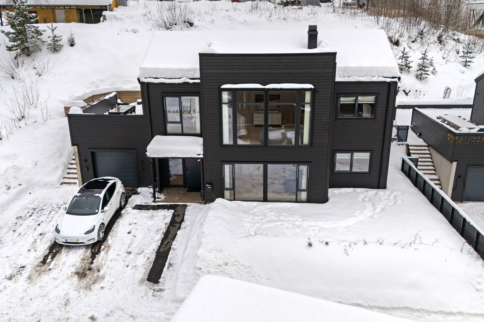 Tomten er på ca. 795 kvm og er opparbeidet med blant annet støttemurer av naturstein, plen og uteområder Varmekabler i hjulsporene utenfor garasjen. Galleribilde