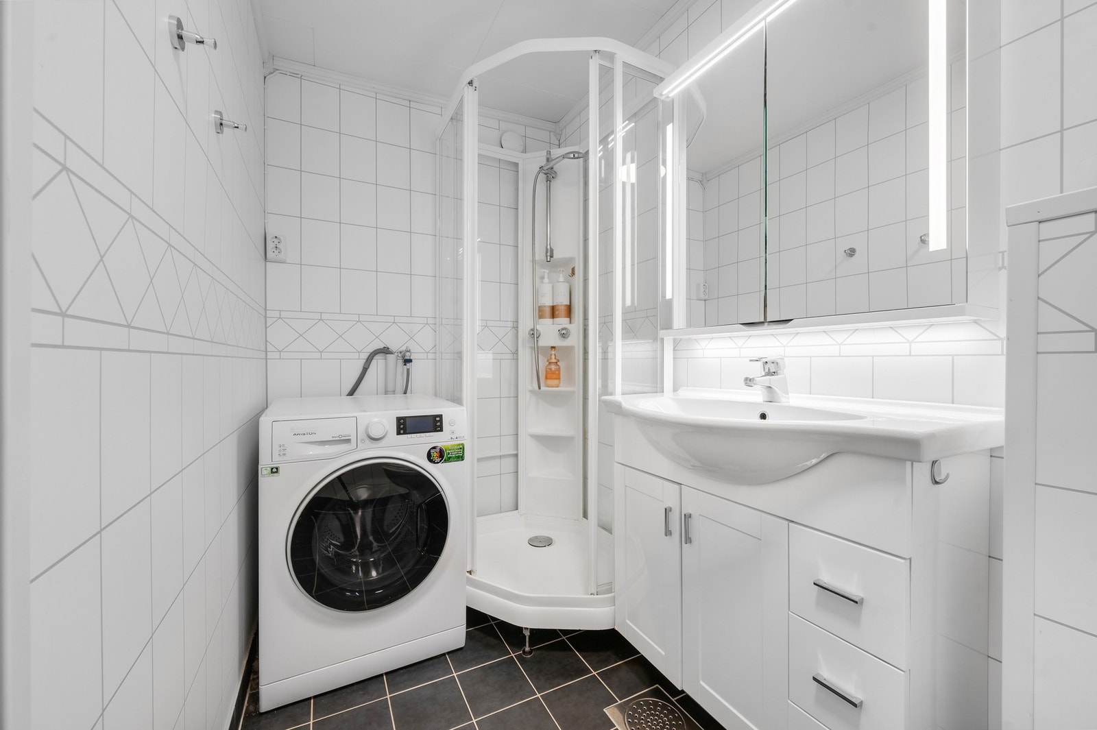 Inners på badet er det dusjkabinett og opplegg for vaskemaskin og tørketrommel. Galleribilde