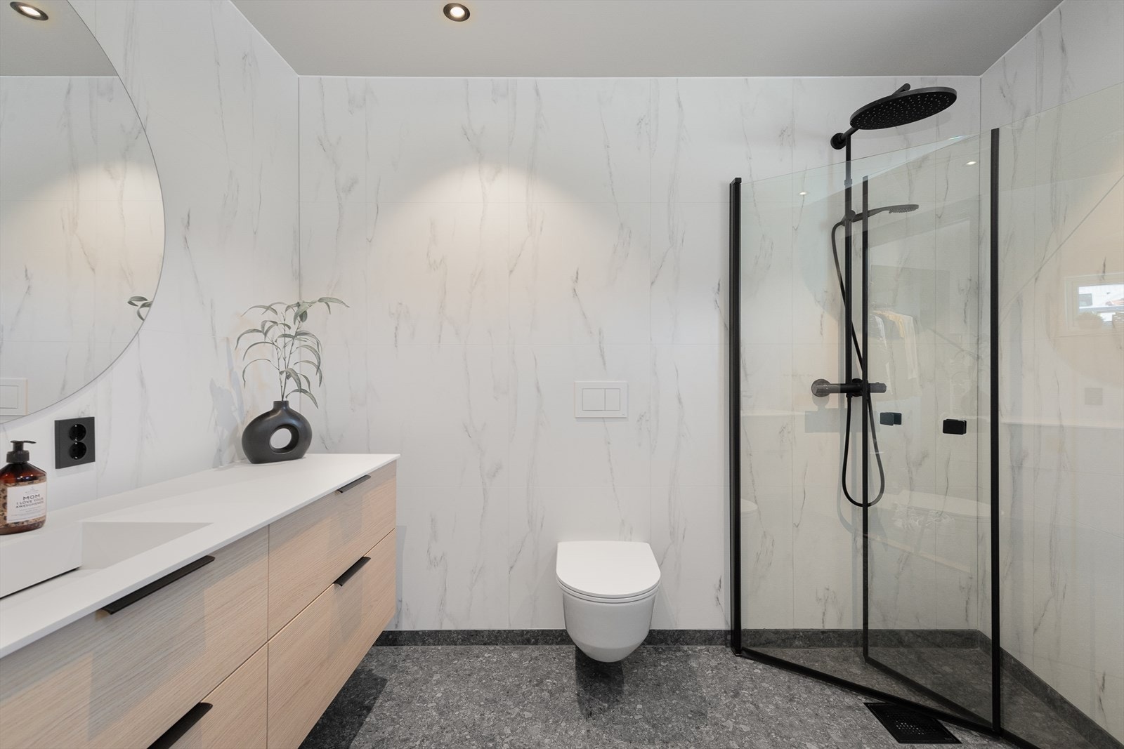 Lyst og delikat baderom med flislagt golv med varmekablar og baderomsplater på vegg. Galleribilde