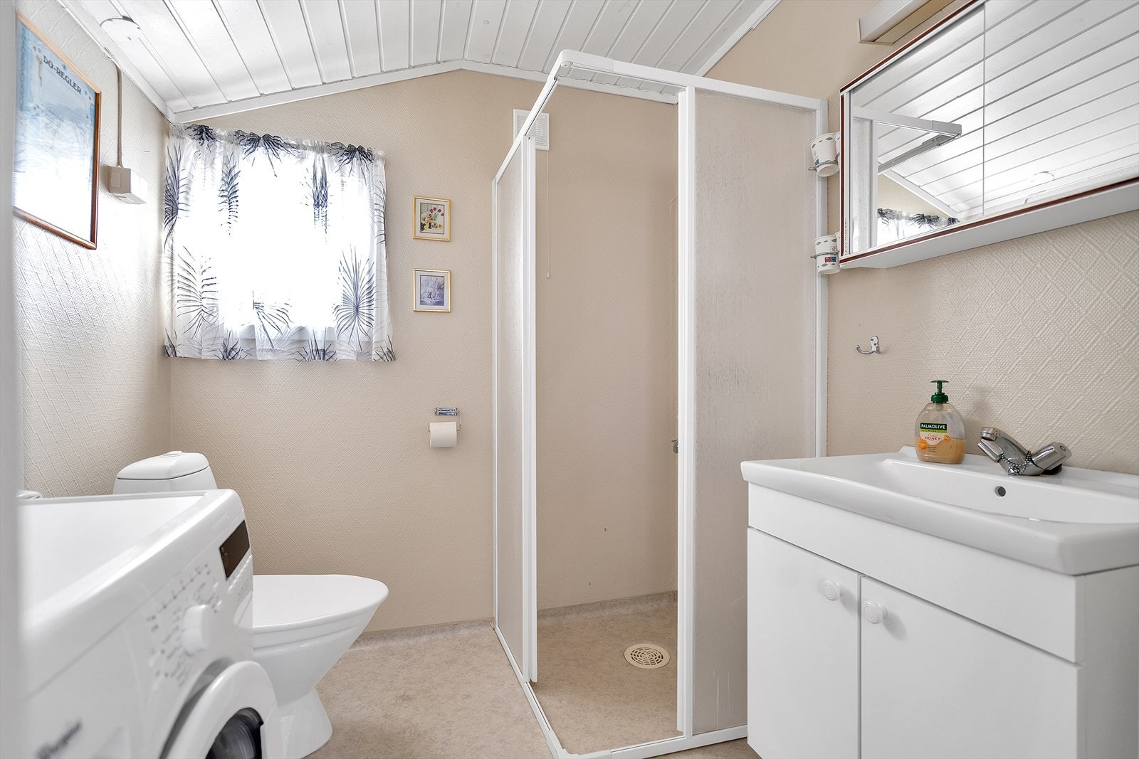 Bad med belegg på gulv og stiretapet, samt opplegg for vaskemaskin Galleribilde