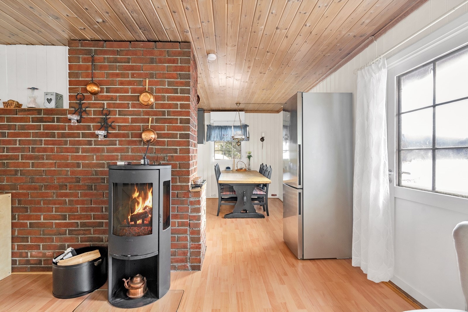 Delvis åpen løsning mellom stue og kjøkken - Vedovn som gir god varme på kalde høst- og vinterkvelder Galleribilde