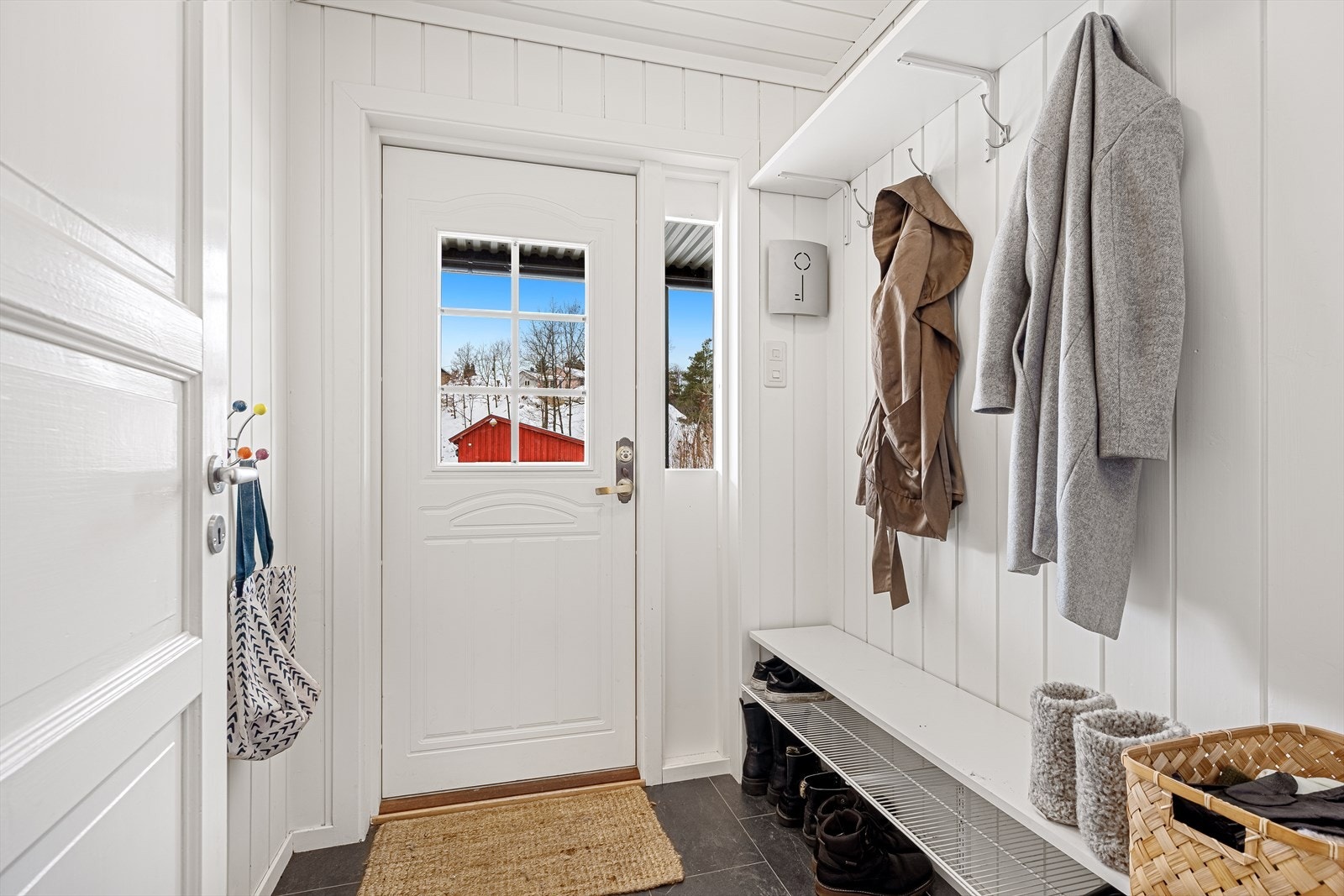 Du kommer først inn i et koselig, lysmalt vindfang hvor det laget en praktisk løsning for sko og oppheng. Galleribilde