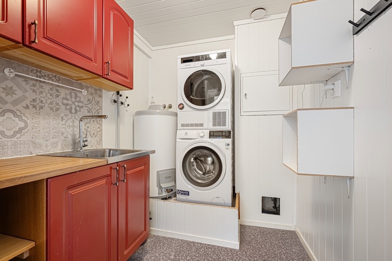 Vaskerom/teknisk rom inneholder opplegg til vaskemaskin, VVB og skapinnredning med utslagsvask. Galleribilde