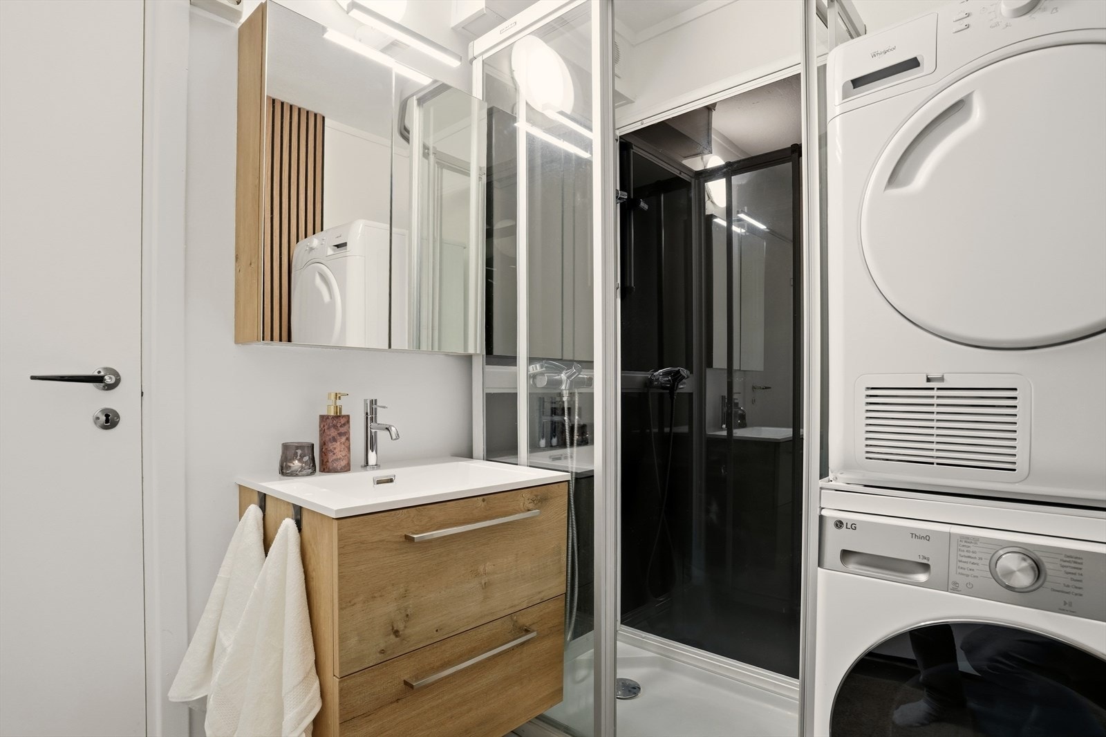 Badet er innredet med nedfelt servant, dusjkabinett og opplegg for vaskemaskin Galleribilde