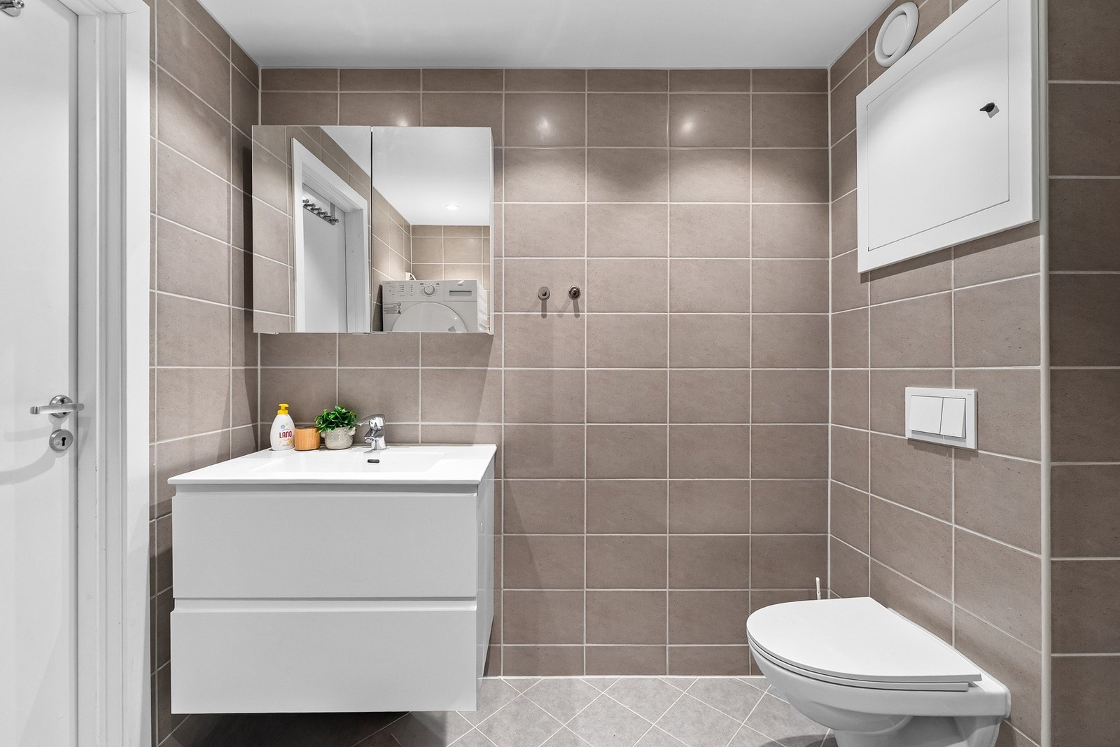 Badet er helfliset med stilrene overflater og har en praktisk planløsning. Galleribilde