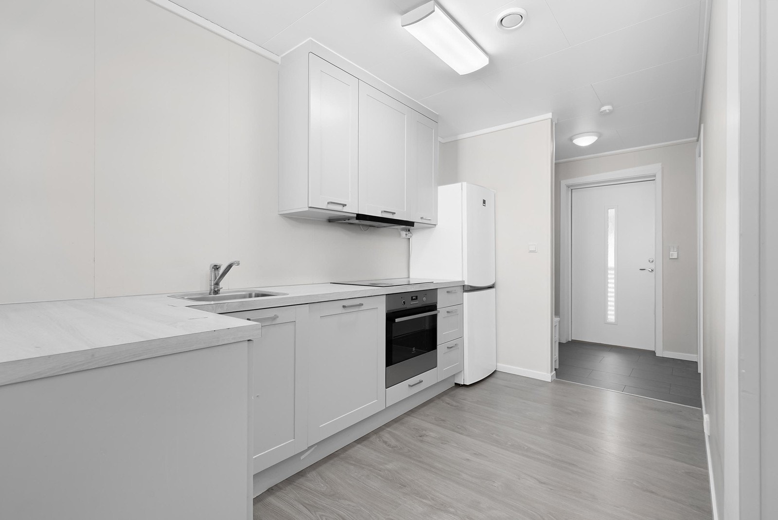 Pent kjøkken med integrert komfyr, platetopp og oppvaskmaskin Galleribilde