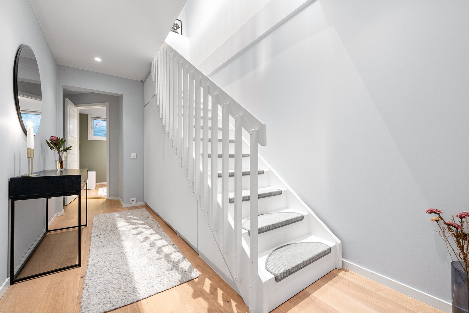 Meget innbydende hall i underetasjen med praktisk, plassbygget skapløsning under trappen som gir rikelig med oppbevaringsplass. Galleribilde