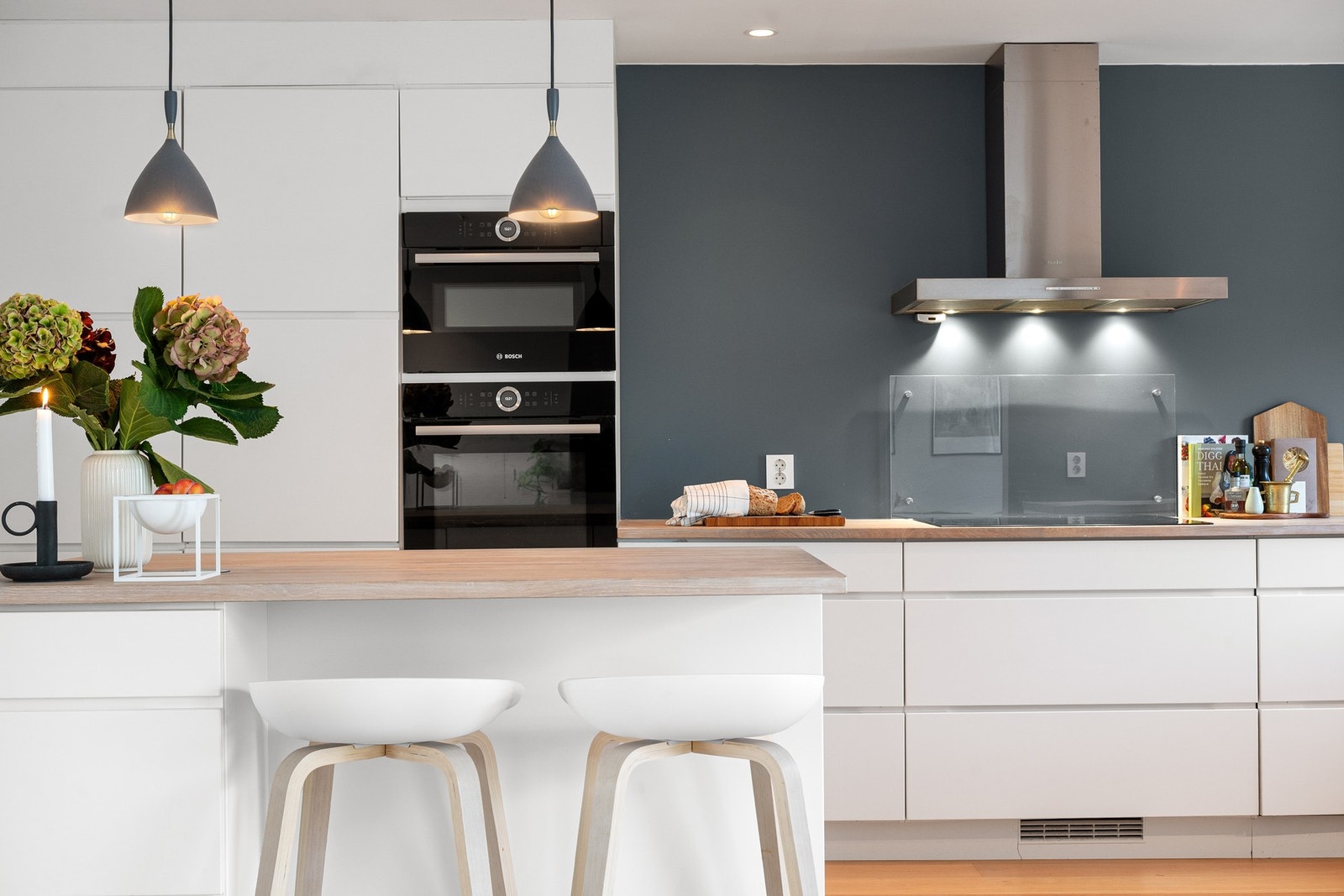 Stilren kjøkkenløsning med praktisk kjøkkenøy som gir ekstra oppbevaring og naturlig sitteplass. Galleribilde