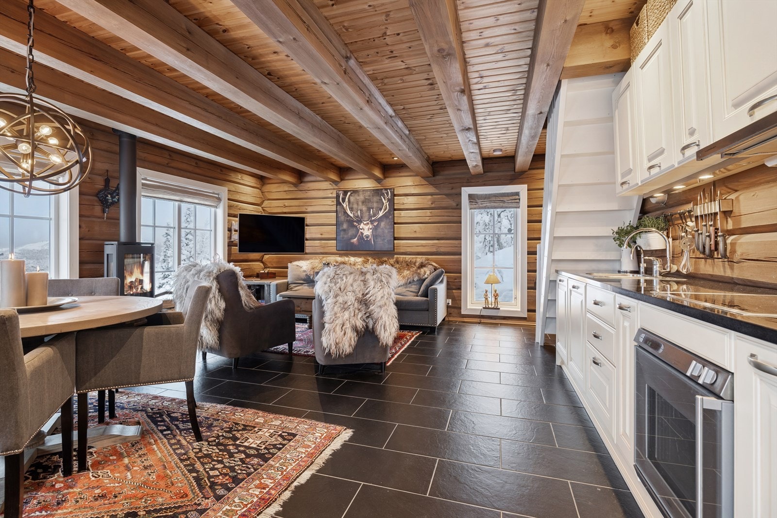 En stemningsfull vedovn fungerer som et naturlig midtpunkt, perfekt for kalde vinterkvelder og hyggelige samlingsstunder Galleribilde