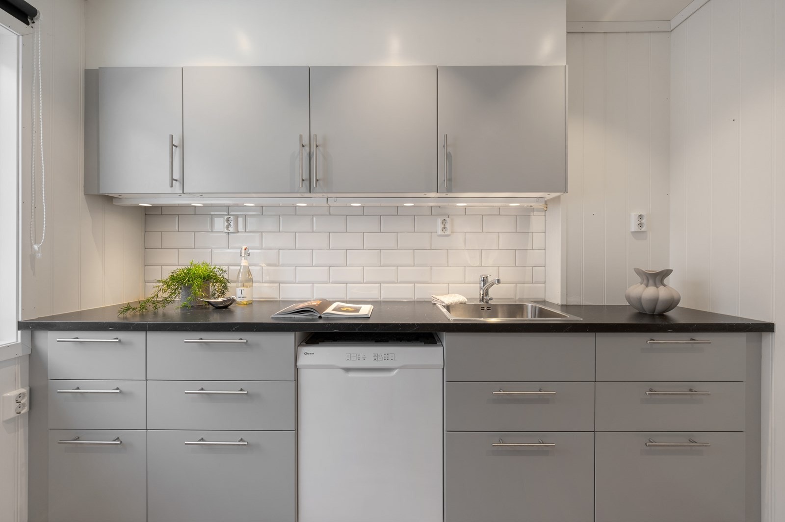 Fliser over benkeplaten og belysning under overskap gir både et estetisk og funksjonelt løft. Galleribilde