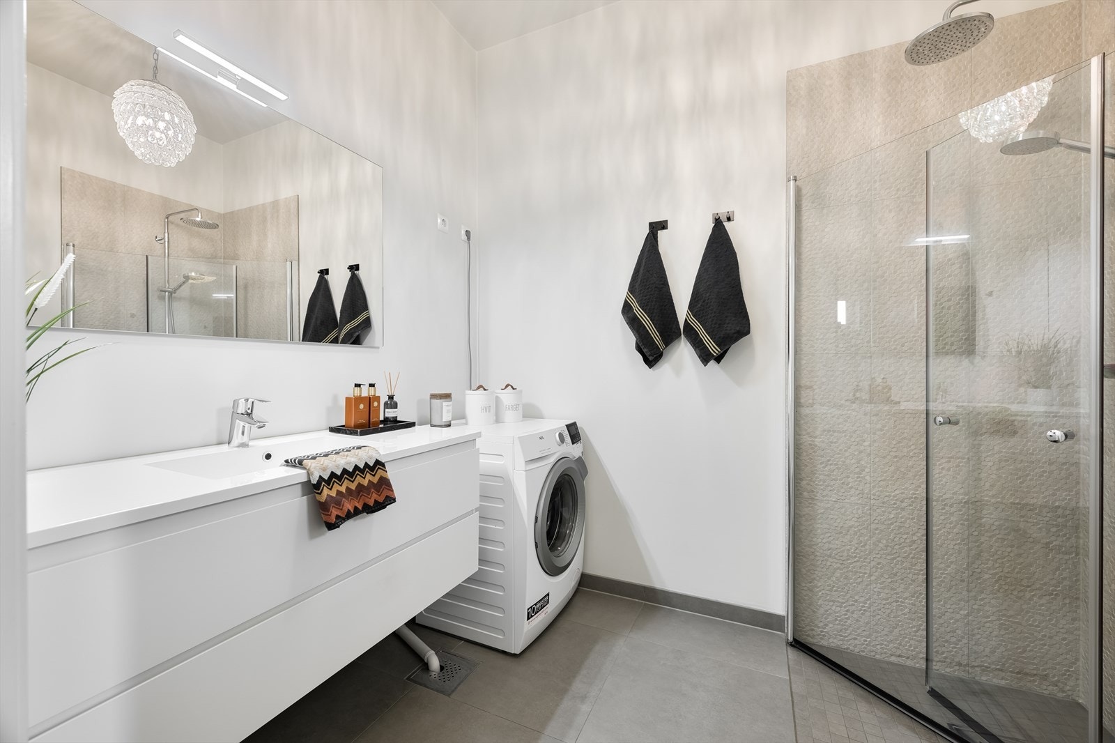 Praktisk plassert bad/vaskerom, inneholder dusjhjørne, wc, pen baderomsinnredning i hvit utførelse Galleribilde