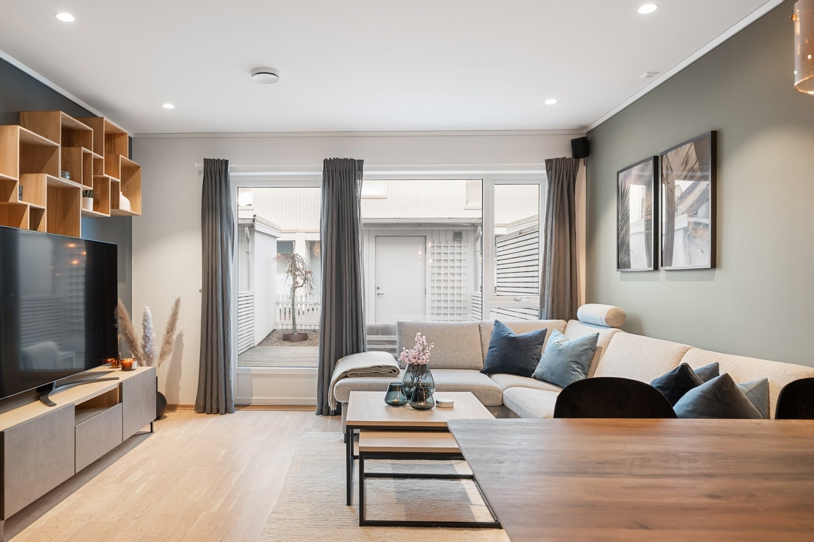 Sammen utgjør stuen og kjøkkenet et åpent allrom, der en stor vindusflate til gulvet slipper inn rikelig med naturlig lys. Galleribilde