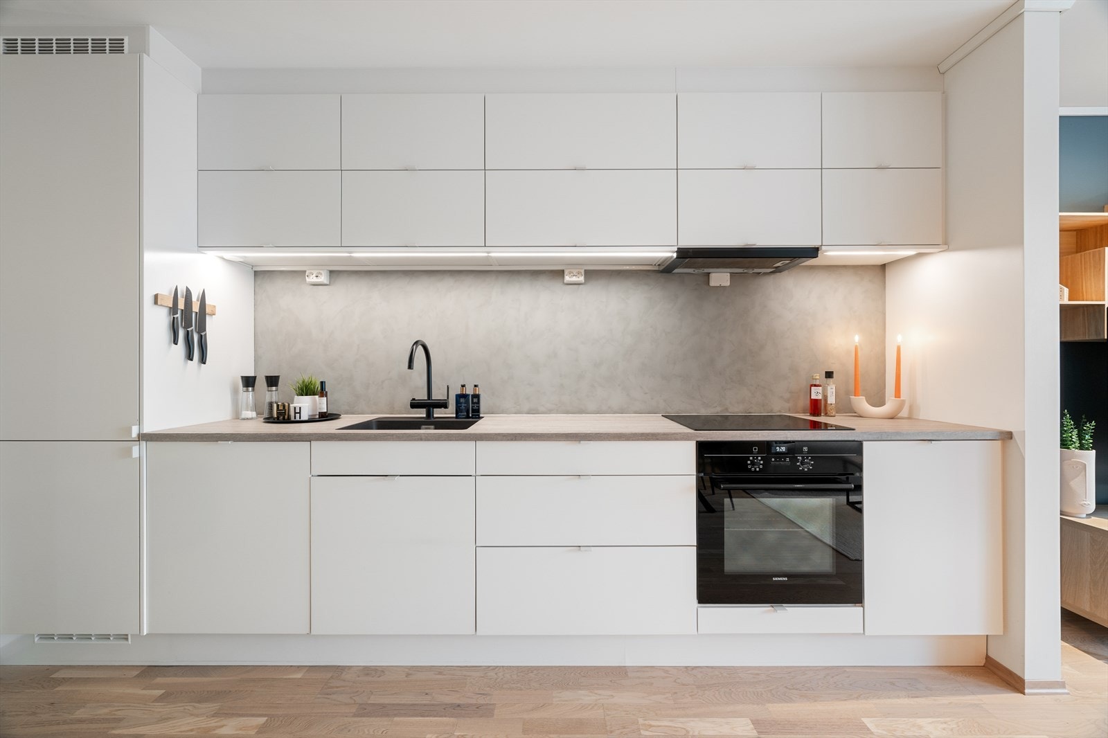 Flott kjøkken som kan vise til pen kjøkkeninnredning i hvit utførelse og integrerte hvitevarer. Galleribilde