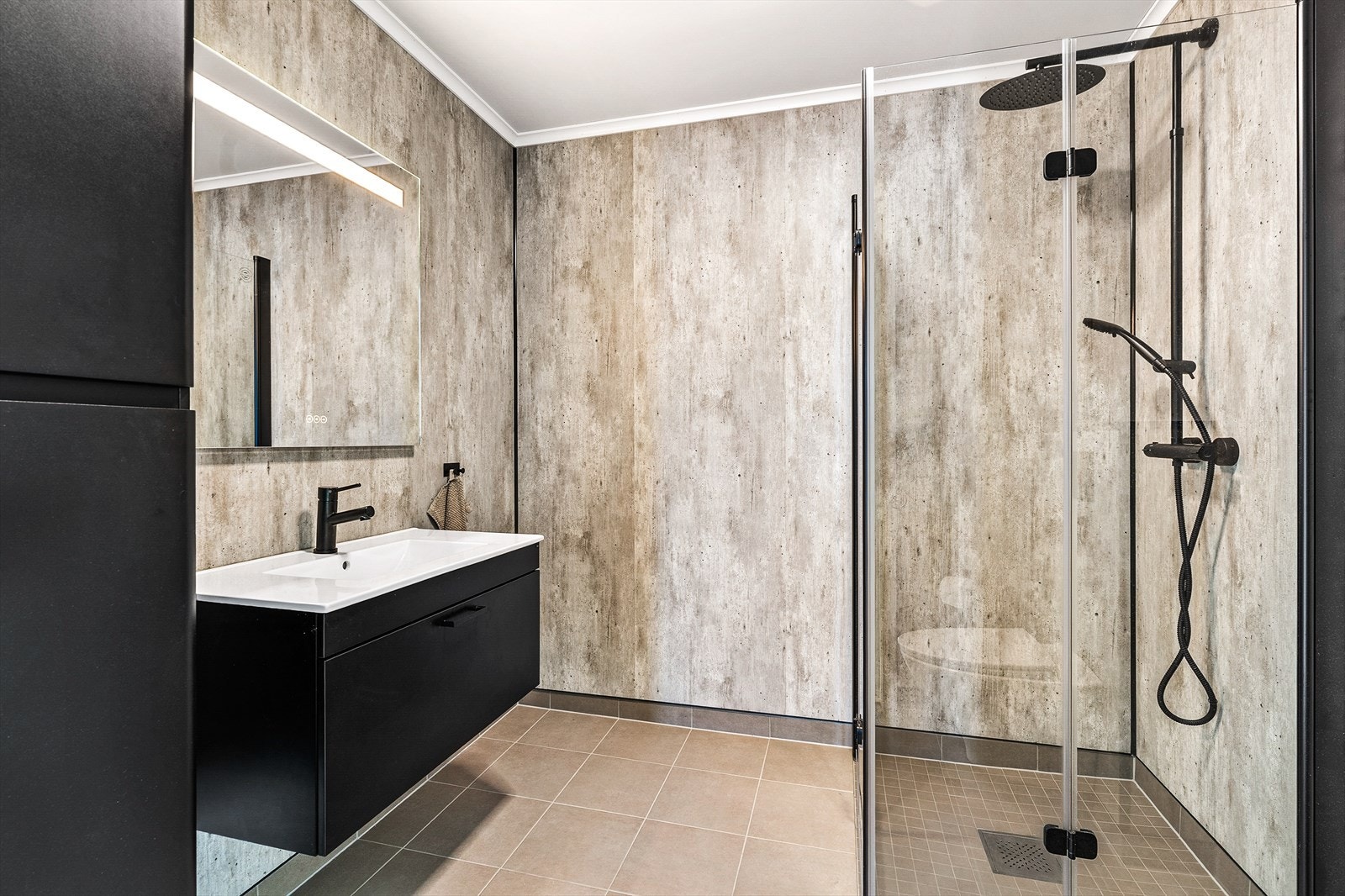 Badet er innredet med nedfelt servant, høyskap, dusjhjørne og vegghengt toalett Galleribilde