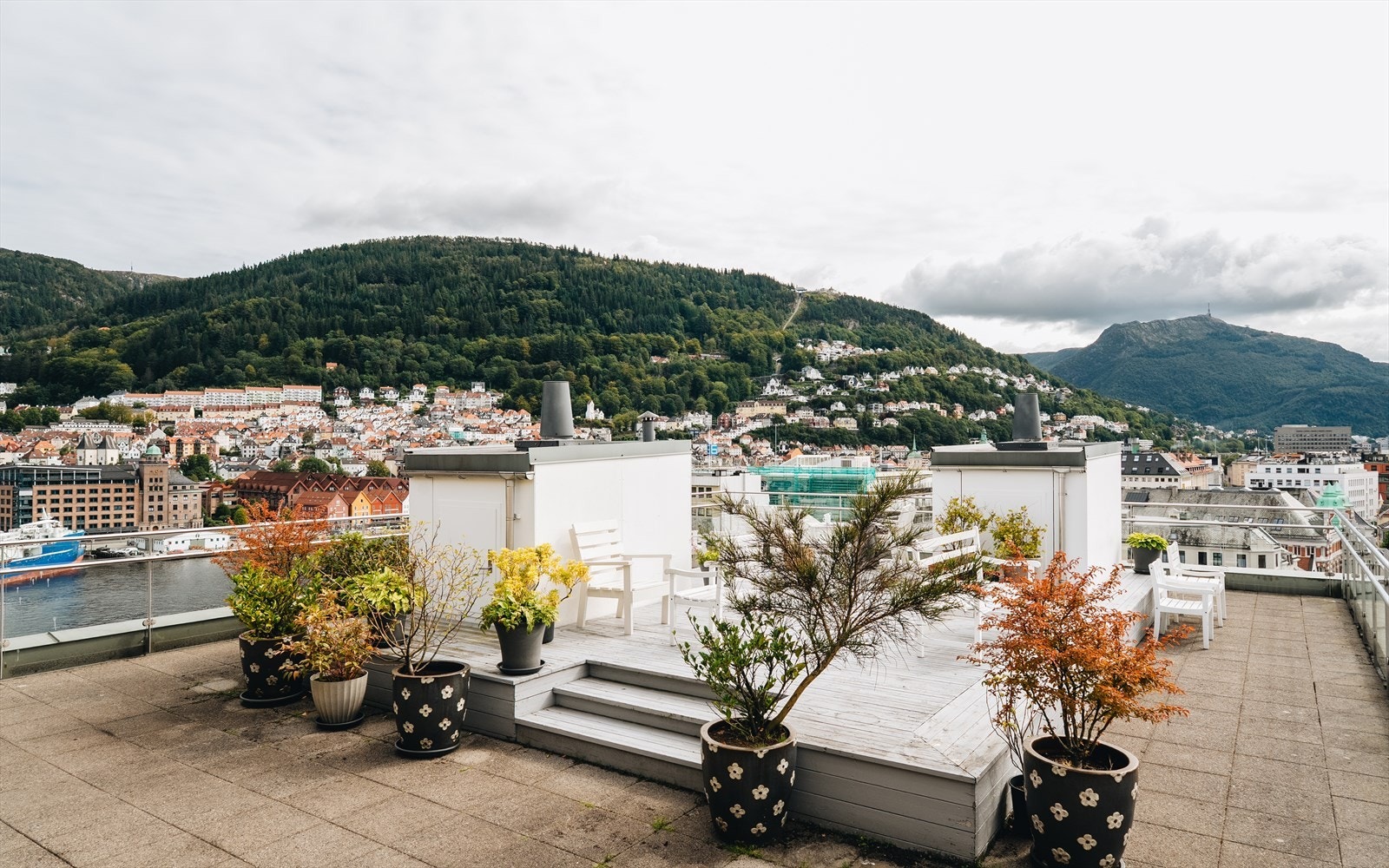 Takterrassen er pent opparbeidet med flere sittegrupper og beplantning. Galleribilde