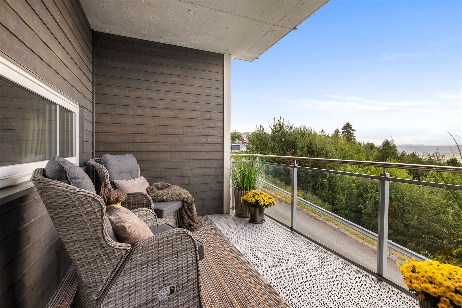 Balkongen er overbygd, har plastheller på gulvet, og rekkverk i glass som ikke hindrer utsikten. Galleribilde