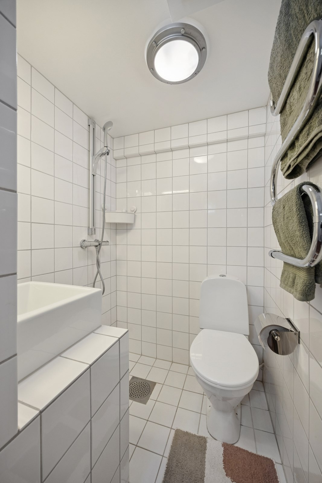 Flislagt bad i kjelleren med dusj og wc. Galleribilde