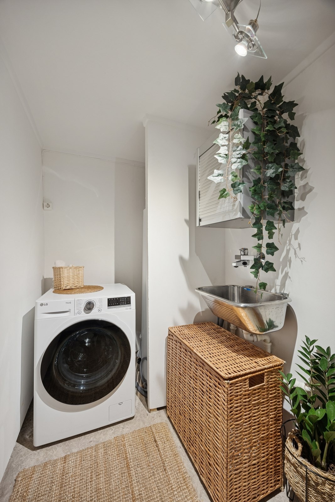 Separat vaskerom med opplegg for vaskemaskin og en varmtvannstank fra 2023. Galleribilde