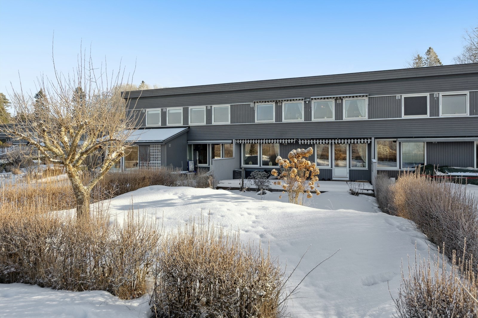 Rekkehus over to plan hvor fasade og tak ble fornyet i 2022 i regi av borettslaget. Galleribilde