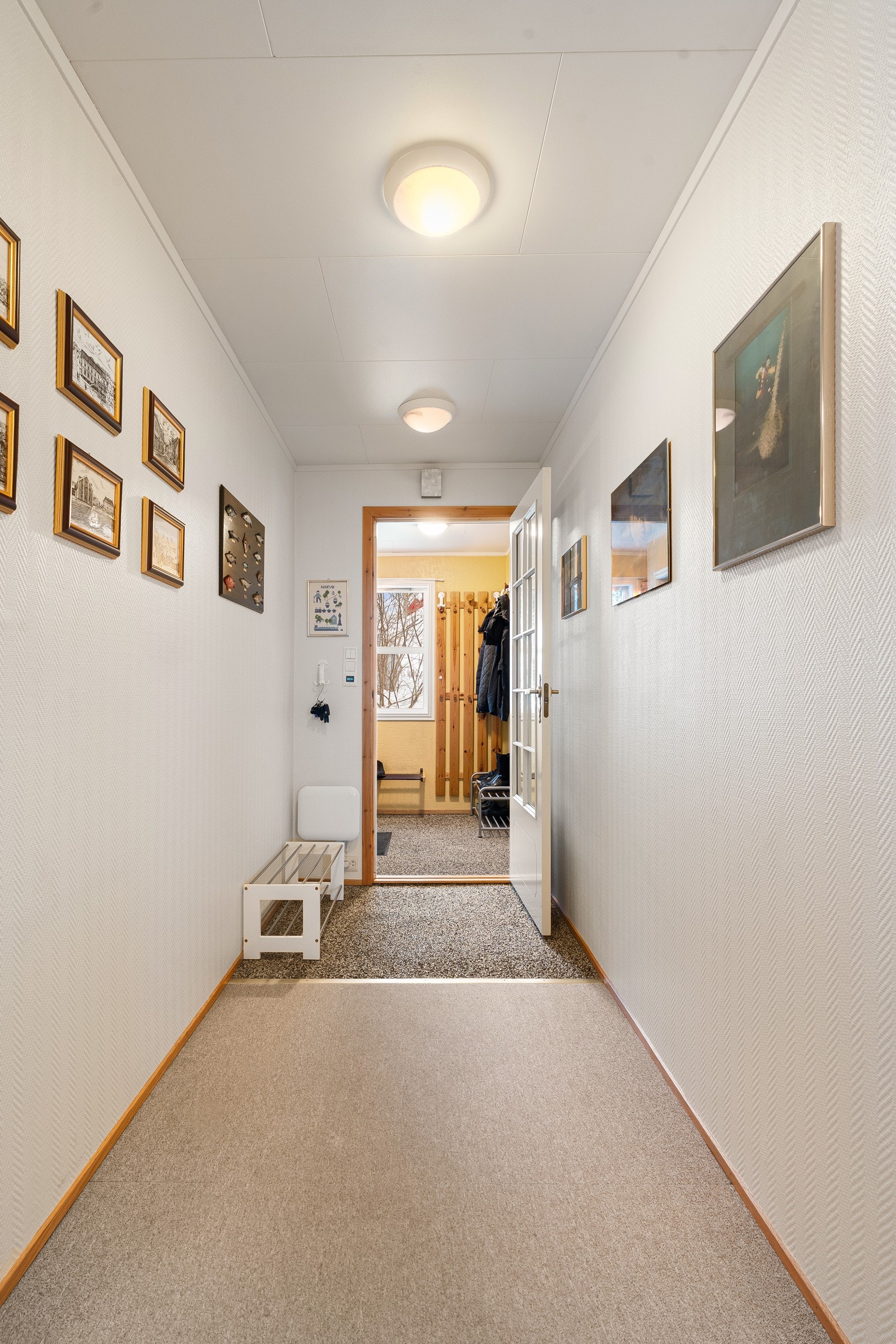 Romslig gang i første plan med plass til kommode eller skoskap