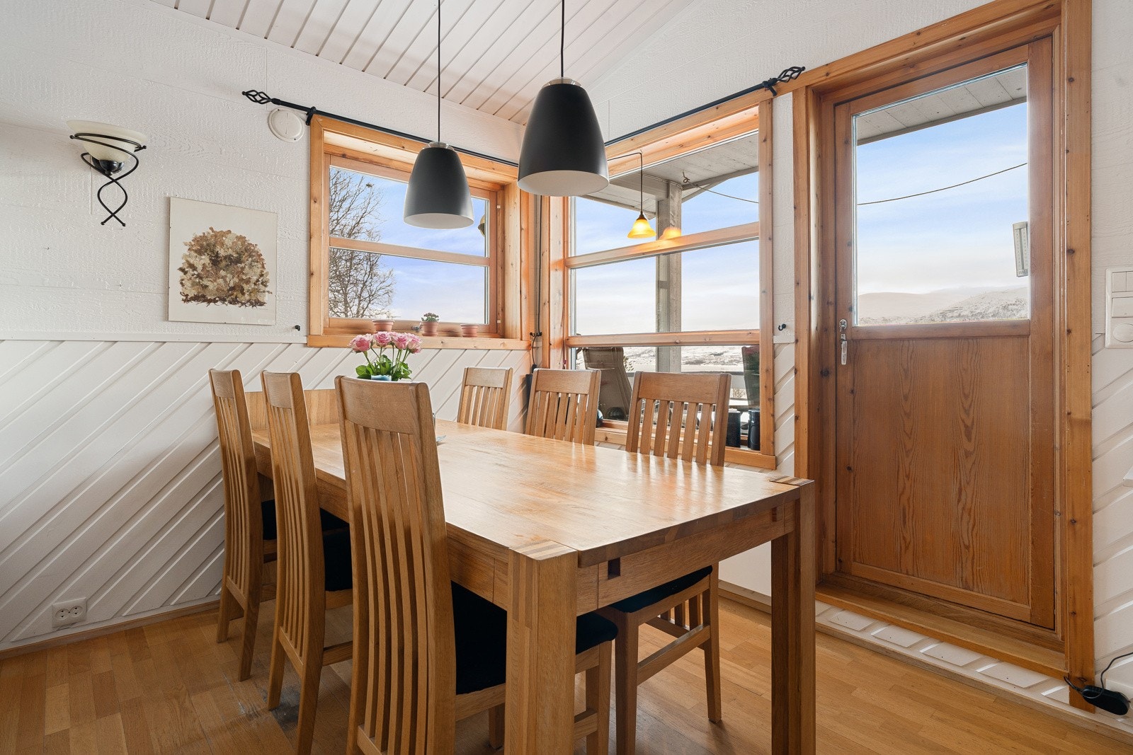 Hyggelig spiseplass med store vinduer som gir rikelig med naturlig lysinnslipp