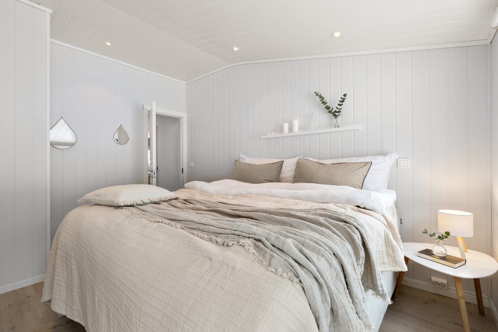 God plass til en stor dobbeltseng med nattbord på hver side. Galleribilde