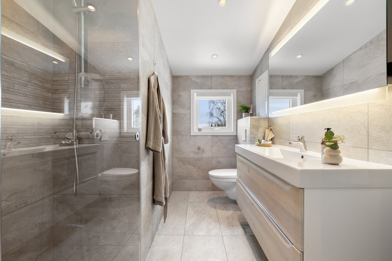 Delikat baderom med behagelig gulvvarme, lekre fliser og moderne innredning. Galleribilde