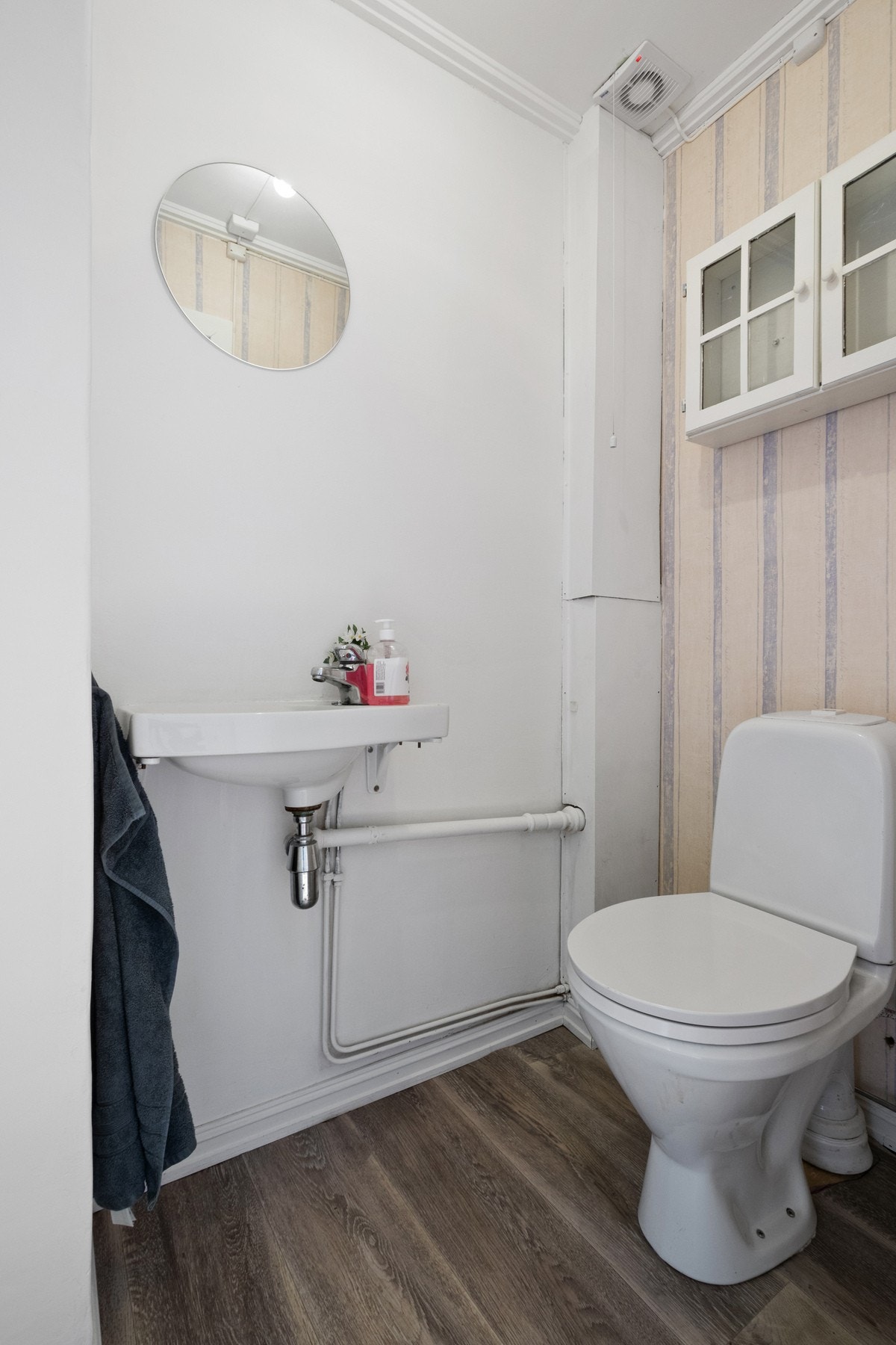 Toalettrom med gulvmontert toalett og håndvask på vegg i loftsetasje. Galleribilde