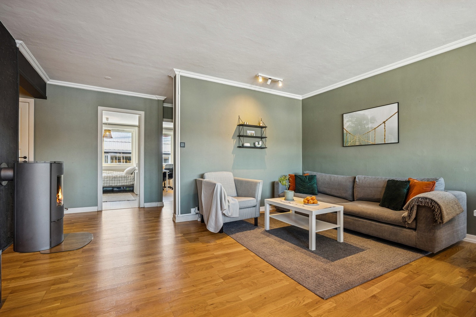 Stuen har en naturlig og hyggelig sofakrok med vedovn som bidrar til ekstra varme og god atmosfære. Galleribilde