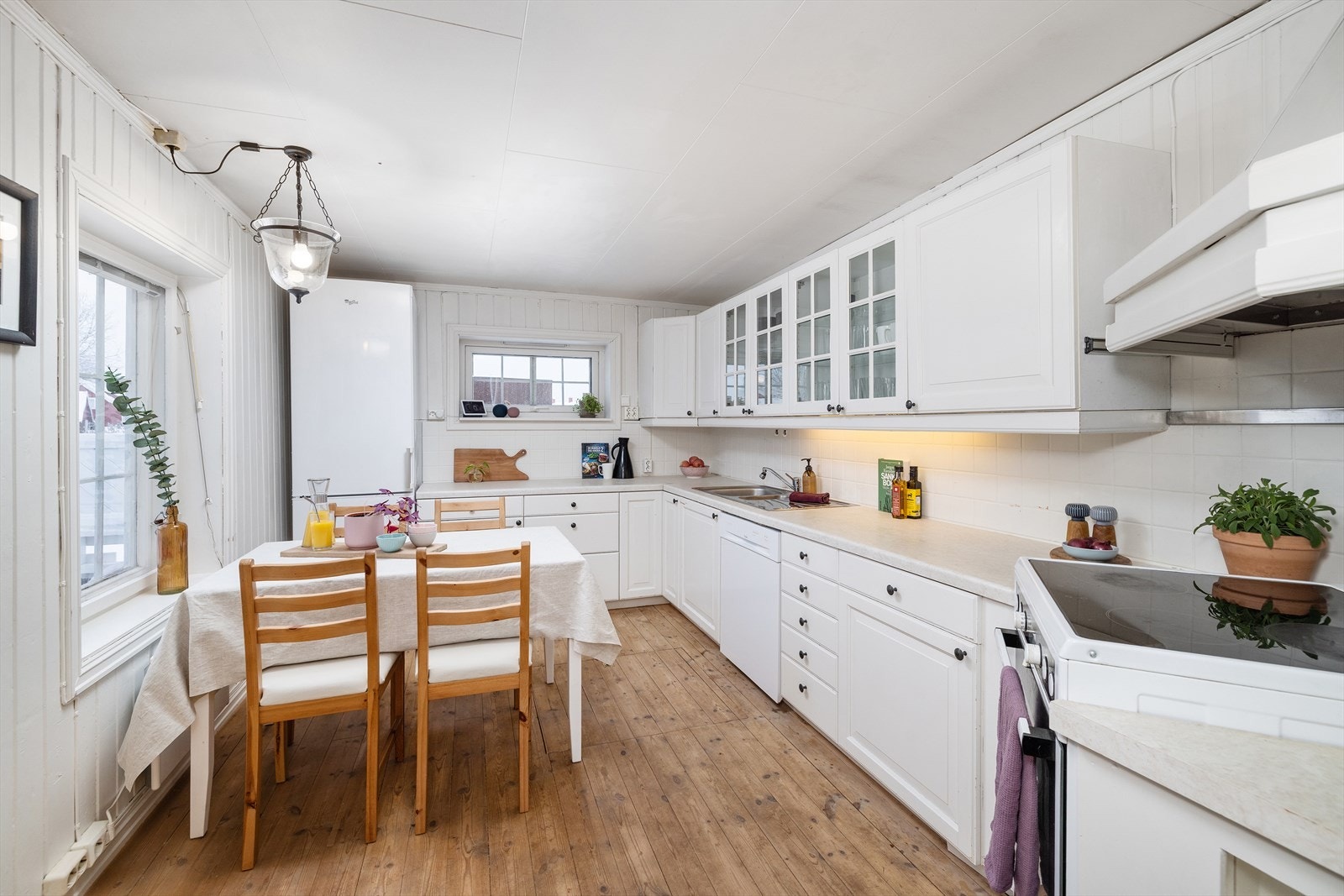 Kjøkkeninnredning med profilerte fronter, laminat benkeplate og belysning under overskap. Galleribilde