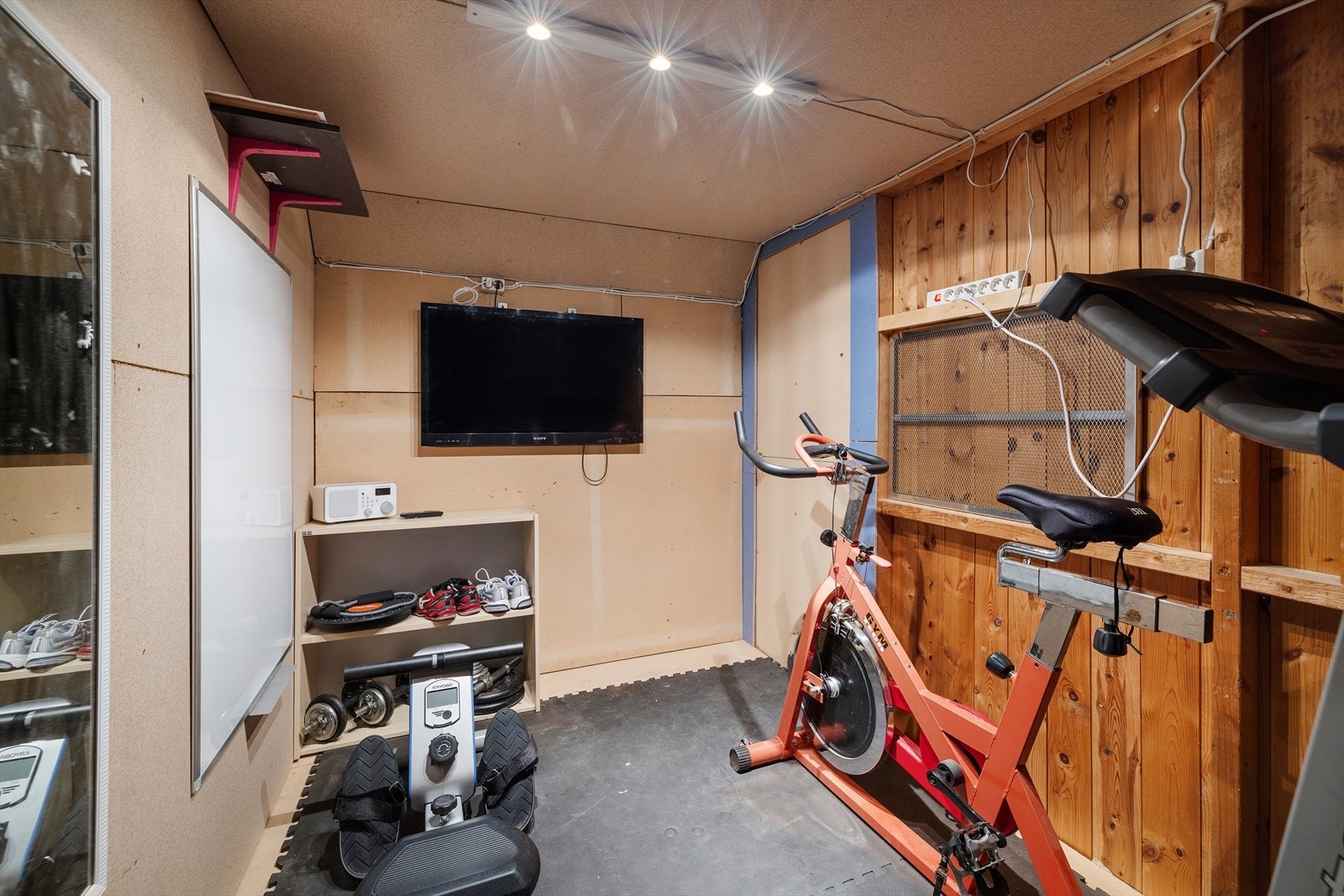 Et av rommene i garasjebygget er innredet som bod/treningsrom. Galleribilde