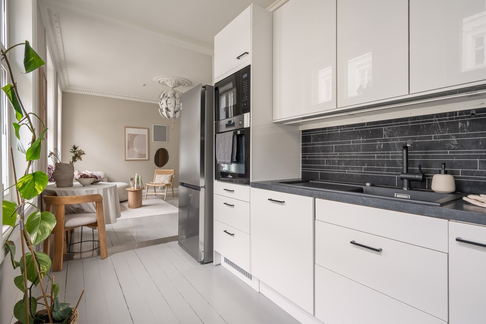 Pent og tidløst Epoq-kjøkken fra 2020, med hvite, glatte høyglansfronter og benkeplate i laminat. Galleribilde