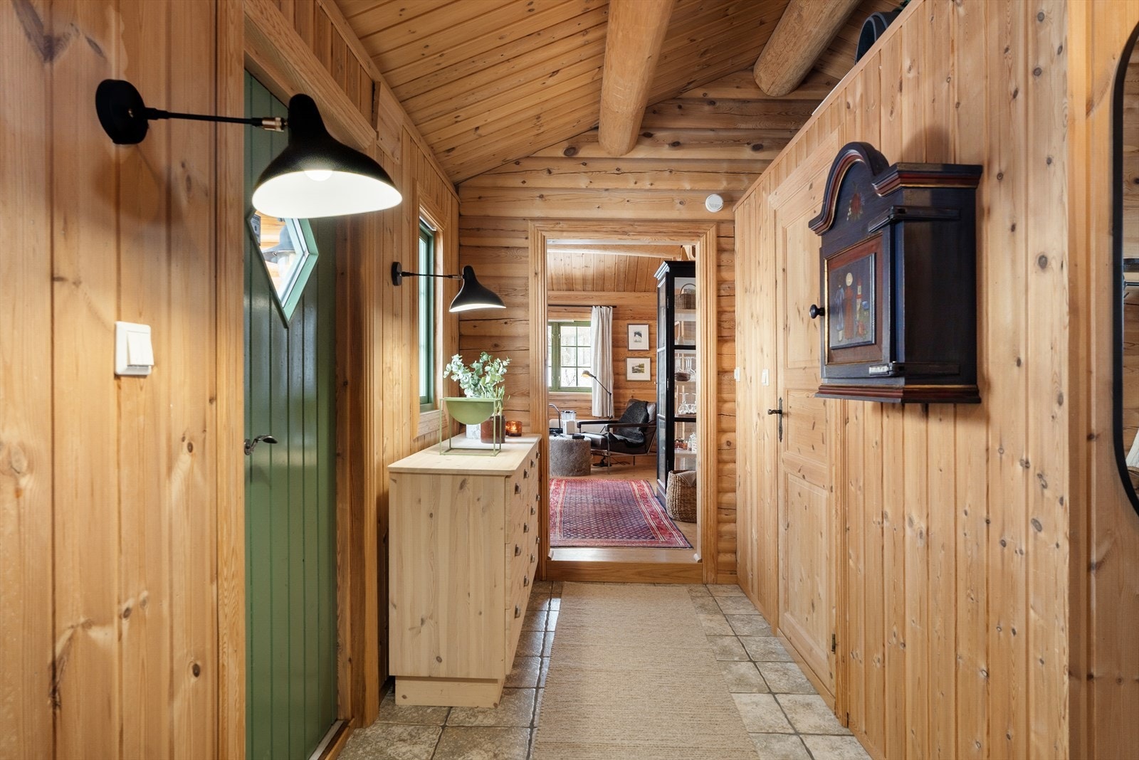 Entré med flislagt gulv. Fra entreen åpner hytta seg opp i et lunt og sosialt allrom. Galleribilde