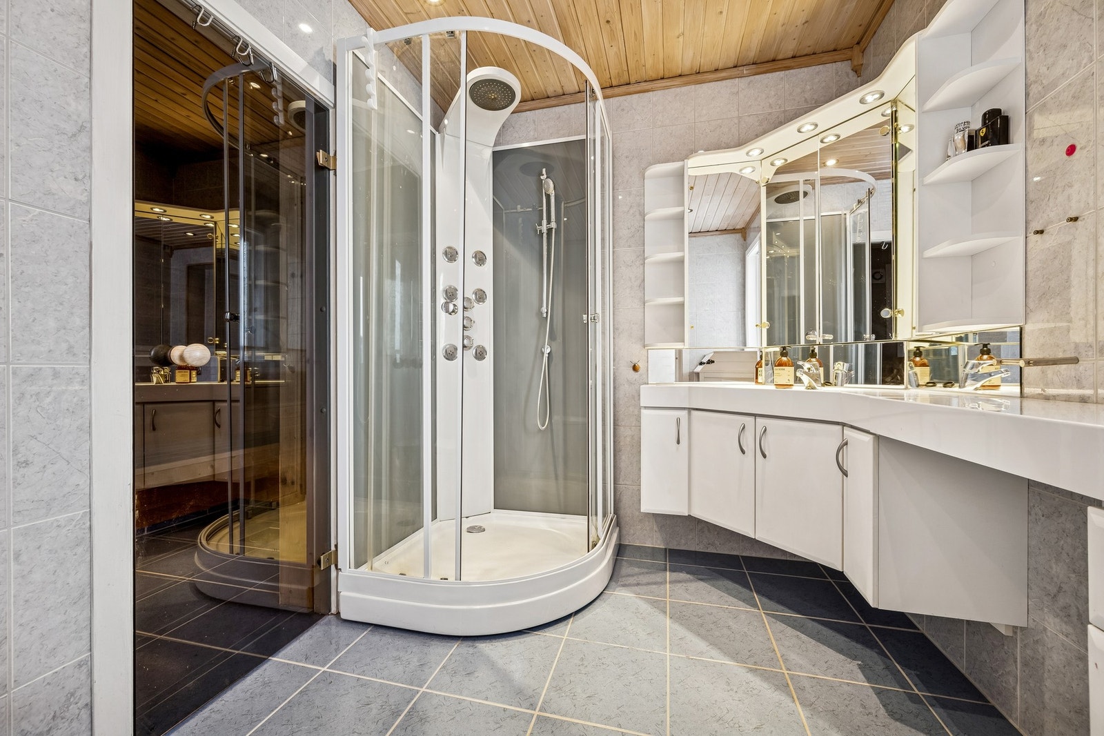 Romslig bad med dusjkabinett, stor baderomsinnredning og toalett, samt direkte adkomst til badstue Galleribilde