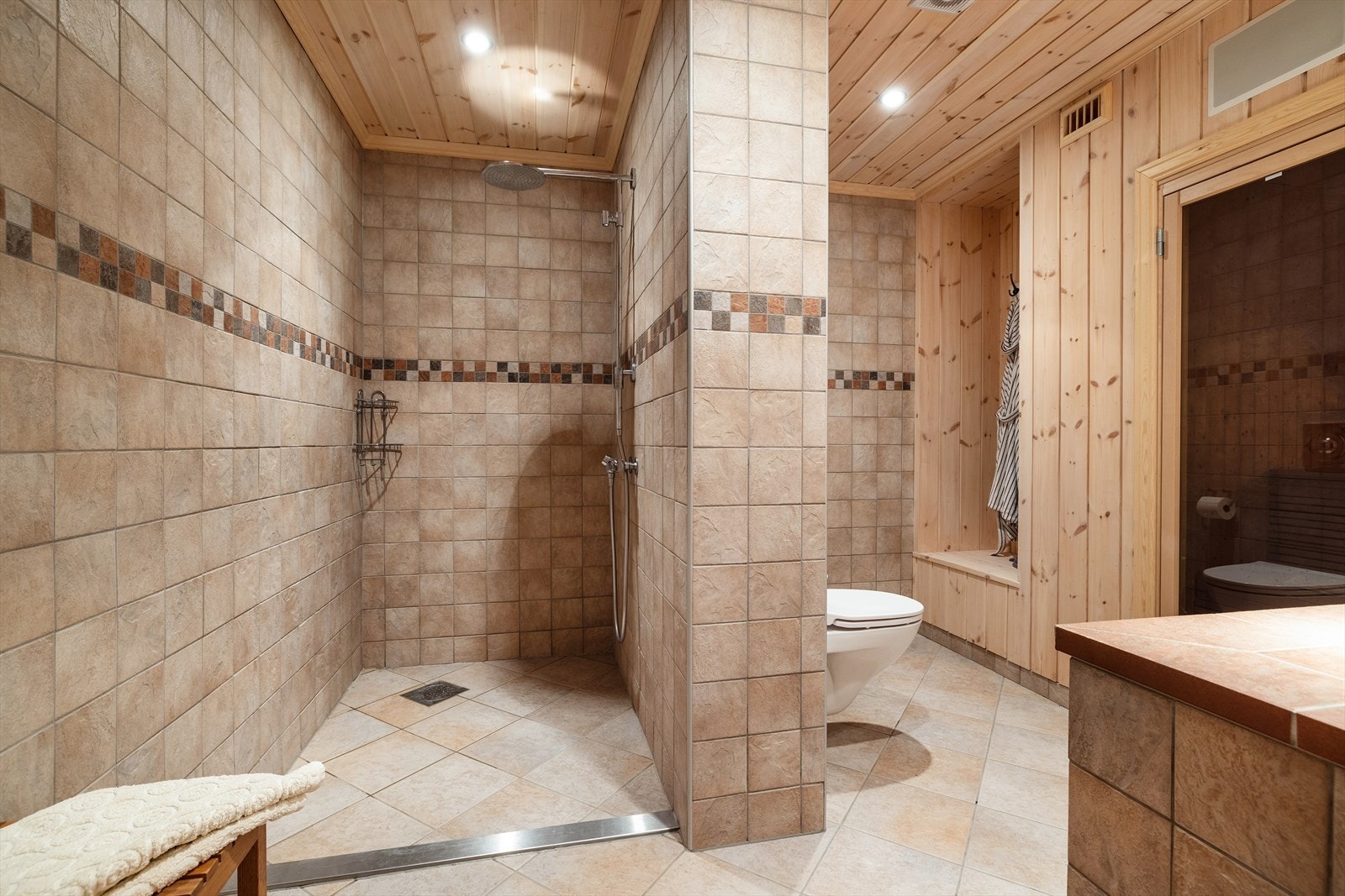 Rommet er innredet med stor dusjnisje, servant og vegghengt toalett. Galleribilde