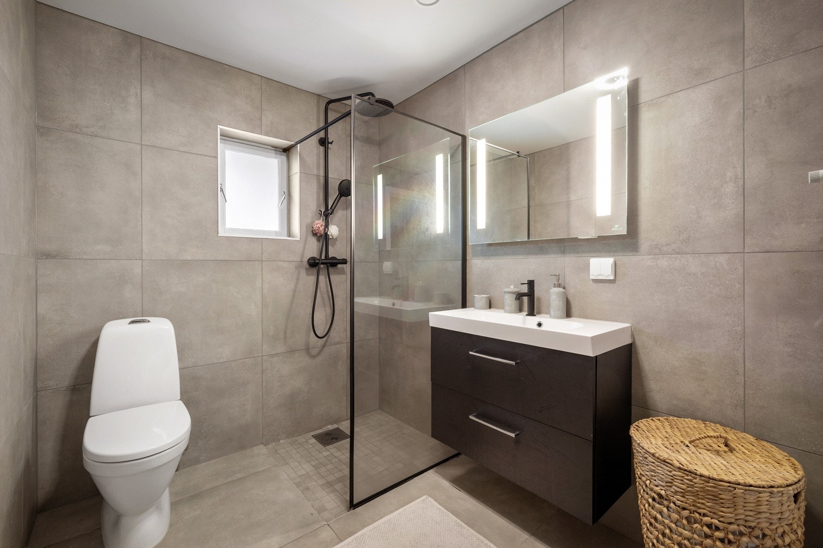 Badet i underetasjen har fliser på gulv og vegger, varmekabler på gulv. Galleribilde